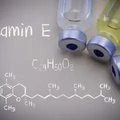 Wizualizacja witaminy E, znanej jako tokoferol, z jej wzorem chemicznym i fiolkami.