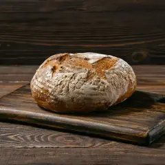 Chleb bezglutenowy na drewnianej desce. Dowiedz się, jak upiec chleb bezglutenowy, by był pyszny i puszysty.