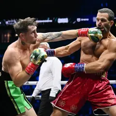 Två boxare i ringen, en träffar den andra i ansiktet. Intensiv action i en misfits boxing-match.
