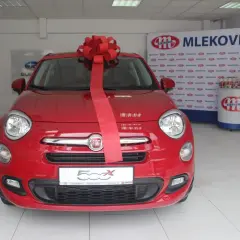 Czerwony Fiat 500X z wielką czerwoną kokardą, gotowy do wręczenia jako nagroda w loterii promocyjnej Vitay.