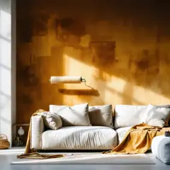 Un salon moderne avec un canapé blanc, un plaid ocre et un mur texturé. La question "la peinture velours est elle lessivable ?" plane, suggérant une rénovation.