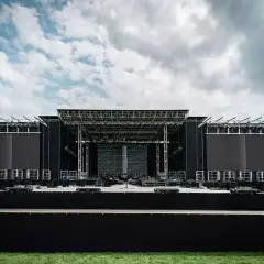 Ogromna scena koncertowa RCF Arena czeka na tłumy. Metalowa konstrukcja, ekrany LED i zielona murawa pod błękitnym niebem.