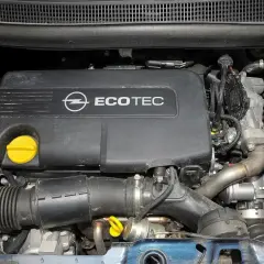 Silnik Ecotec w Opel Meriva 1.7 CDTI. Widoczny czarny plastikowy dekiel z logo Opla i napisem Ecotec, żółty korek oleju, przewody i elementy układu dolotowego.