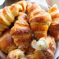 Brioches dorate e soffici, spolverate di zucchero a velo, perfette per la tua ricetta brioches pasticceria.