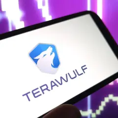 Smartphone zeigt das Logo und den Namen "TERAWULF" vor einem lila Börsenchart. Die Terawulf Aktie im Fokus.