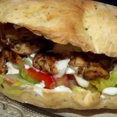 Pyszny kebab w picie z soczystym kurczakiem, świeżą sałatą, pomidorem i kremowym sosem. Idealny na szybki posiłek.