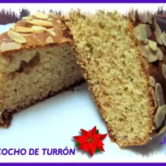 Dos porciones de bizcocho de turrón y yogur, cubiertas con almendras laminadas. Un postre casero delicioso.