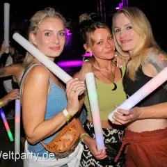 Drei Frauen mit leuchtenden Stäben auf einer Veranstaltung in Herrieden.