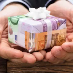 Oto jak śmiesznie zapakować pieniądze na prezent: banknoty euro tworzą małe pudełko przewiązane białą wstążką.