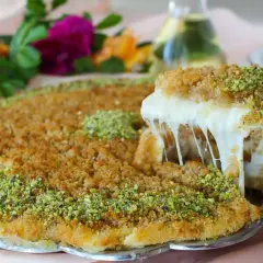 En bit krämig kunafa med smält ost som dras ut, toppad med pistagenötter. Ett läckert kunafa recept att prova!