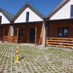 Drewniane domki na kempingu w Rewalu, z werandami i miejscami parkingowymi. Idealne na wakacje nad klifem.