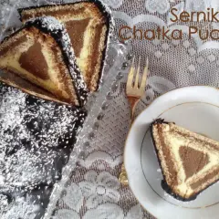 Ciasto "Chatka Puchatka" z polewą czekoladową i wiórkami kokosowymi. Na talerzyku kawałek ciasta w kształcie trójkąta.