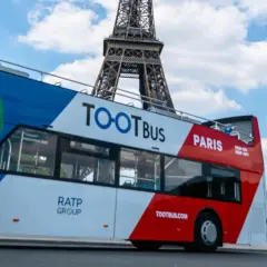 Ekologiczny autobus wycieczkowy Tootbus w Paryżu, z widoczną Wieżą Eiffla w tle. Idealny sposób na zwiedzanie Paryża samochodem.