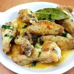 Alitas de pollo al ajillo, doradas y jugosas, bañadas en una salsa aromática con ajo y perejil fresco. Un plato delicioso.