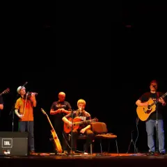 Zespół gra na gitarach i skrzypcach. W tle słychać **stare dobre małżeństwo utwory**.