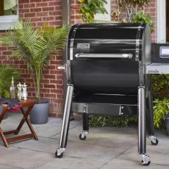 Nowoczesny, czarny grill na drzewo Weber SmokeFire z cyfrowym panelem sterowania, gotowy do przygotowania pysznych potraw na tarasie.