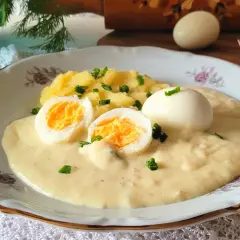 Jajka w sosie chrzanowym z ziemniakami, udekorowane szczypiorkiem. Pyszne danie, które rozpływa się w ustach.