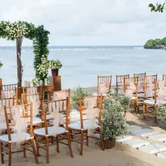 Ustawione krzesła i łuk z kwiatami czekają na ślub na plaży. Romantyczna sceneria nad morzem.