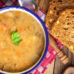 Gęsta grochówka z kawałkami mięsa i warzyw, podana z chlebem. Idealny przepis na rozgrzewający posiłek.