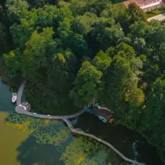 Malownicze pojezierze lubuskie z żaglówką na wodzie, drewnianym pomostem i bujną zielenią drzew.