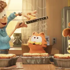 Jon reibt Käse für Lasagne, während Garfield und Odie gespannt zuschauen. Ein Festmahl für garfield – eine extra portion abenteuer!