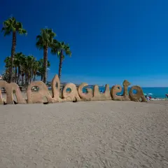 Piaskowy napis "Malagueta" na plaży, palmy i błękitne morze. Czy Malaga ma dostęp do morza? Tak, jak widać!