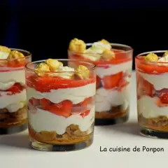 Quatre verrines fraise mascarpone superposant biscuits émiettés, crème onctueuse, fraises fraîches et coulis, surmontées de chantilly et de pop-corn caramélisé.
