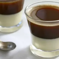 Dwa szklanki kawy z mlekiem skondensowanym, jedna z łyżeczką. Idealny poranek z kawą.