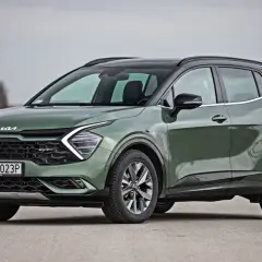 Nowy zielony Kia Sportage GT-Line, jeden z najnowszych kia modele, prezentuje się na drodze.
