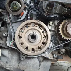 Widok na mechanizm napędu rozrządu silnika. Widać koła zębate, napinacz i pasek. Czas na wymianę rozrządu!