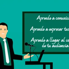 Un orador sonriente, con un traje negro y corbata blanca, presenta en una pizarra. La pizarra muestra un ejemplo de qué es una anáfora: "Aprende a comunicar, Aprende a expresar tus ideas, Aprende a llegar al corazón de tu audiencia".