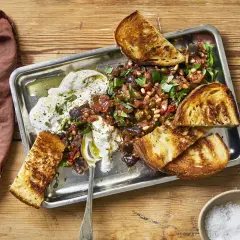 En härlig rasta frukost med krämig ost, grönsaksröra och rostat bröd på ett metallfat.