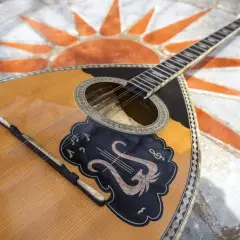 Piękny grecki instrument muzyczny, bouzouki, leży na mozaice w kształcie słońca.