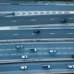Widok z góry na autostradę, gdzie samochody wykonują manewry **wymijania** i **omijania** przeszkód, tworząc dynamiczny obraz ruchu drogowego.