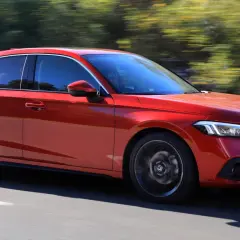 Czerwony Honda Civic 11 na drodze, z rozmytym tłem drzew.
