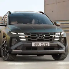 Hyundai Tucson hybrid test. En mörkgrön SUV med distinkta LED-lampor och en modern grill.