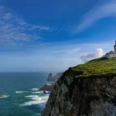 Majestatyczny **Cabo da Roca** z latarnią morską na szczycie klifu, gdzie ocean spotyka ląd.