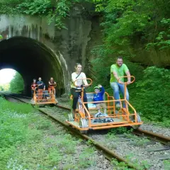 Rodzina na drezynach rowerowych przed tunelem w Bieszczadach.