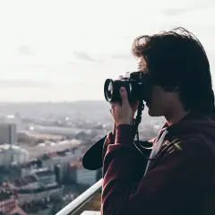 Młody mężczyzna, którego pasją jest fotograficzny zawód, uchwycił panoramę miasta.