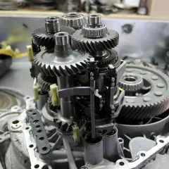 Mechanizm skrzyni biegów z widocznymi kołami zębatymi i łożyskami. Objawy zużycia łożyska skrzyni biegów mogą być różne.
