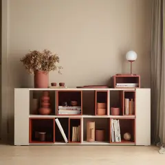 Nowoczesna biblioteczka z elementami w kolorze terakota, wypełniona książkami i dekoracjami.