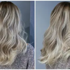 En kvinna med vackert, vågigt hår i en "old money blonde"-nyans. Håret har en naturlig, solkysst look med ljusa slingor.
