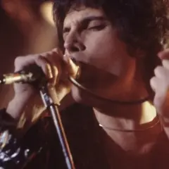 Freddie Mercury śpiewa z pasją, jakby chciał porwać tłumy. Choć nie ma tu dzieci, jego muzyka to dziedzictwo dla przyszłych pokoleń.