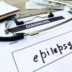 Stetoskop na dokumencie z napisem "DIAGNOSIS" i odręcznie wpisaną diagnozą: epilepsja.