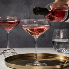 Różowe wino nalewane do eleganckich kieliszków. Idealny wieczór z przyjaciółmi przy lampce orzeźwiającego różowego wina.