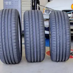 Trzy nowe opony, każda z nich to opona zr17, stoją obok siebie na podłodze warsztatu.