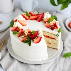En vacker tårta med fluffig grädde och färska jordgubbar, perfekt för att baka med jordgubbar.