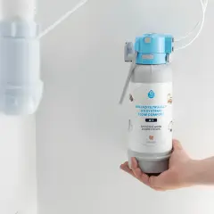 Dłoń trzyma wkład filtrujący do systemu FLOW COMFORT. Czy filtry do wody są zdrowe? Tak, zapewniają smaczną wodę prosto z kranu.
