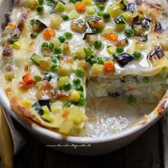 Lasagne alle verdure ricetta della nonna: strati di pasta, besciamella cremosa e un ricco mix di zucchine, carote, melanzane e piselli, gratinate al forno.