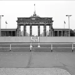 Brama Brandenburska z tablicą "ACHTUNG Sie verlassen jetzt West-Berlin", symbolizująca czas, kiedy powstał mur berliński.